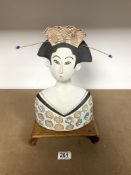 A JAPANESE STONEWARE POTTERY BUST, 33 CM, ON A MINIATURE OPIUM TABLE WITH A BLACK AND GOLD LACQUER