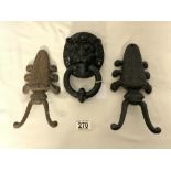 THREE CAST IRON PIECES TWO DOOR STOPS AND A LION FACE DOOR KNOCKER