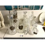 SIX CUT GLASS DECANTERS AND A SCENT BOTTLE, WITH 2 HALLMARKED SILVER LABELS AND OTHERS.