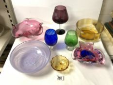 FOUR COLOURED ART GLASS BOWLS, 24 CMS DIAMETER [ LARGEST ], AND 3 COLOURED GLASS DRINKING GLASSES.