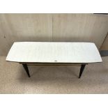 A 1960s RECTANGULAR MELAMINE TOP COFFEE TABLE WITH BRASS FITTINGS, 120X40 CMS.