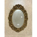 VINTAGE GILDED OVAL MIRROR DECORATED WITH CHERUBS HOLDING A CROWN 69 X 47CM