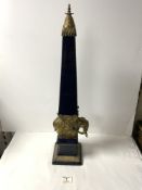 A BLUE CERAMIC AND BRASS ELEPHANT SUPPORT OBELISK, 66 CMS.