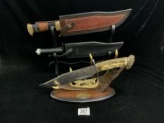 A HIGHLY DETAILED WOLF HUNTING KNIFE ON MATCHING STAND, WITH 2 REPLICA BOWIE KNIVES.