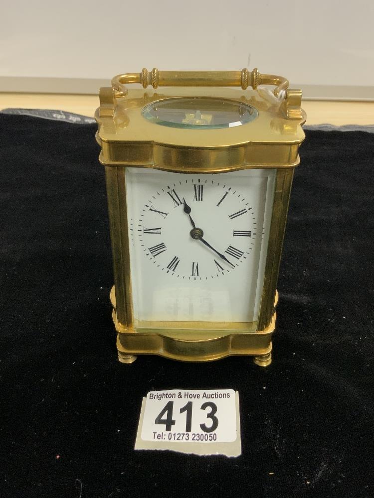 BRASS CARRIAGE CLOCK OF SHAPED OUTLINE WITH WHITE ENAMEL DIAL; W/O; WITH KEY; 12CM