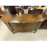 A 1930s WALNUT SHAPED BOW FRONTED SIDEBOARD ON CARVED CABRIOLE LEGS AND BRASS SWAN NECK HANDLES;