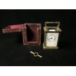 BRASS CARRIAGE CLOCK WITH WHITE ENAMEL DIAL; 11CM WITH A LEATHER OUTER CASE AND KEY
