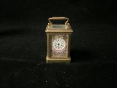 MINIATURE FRENCH CLOCK WITH HAND PAINTED ENAMEL IN BRASS CASING; 8CM