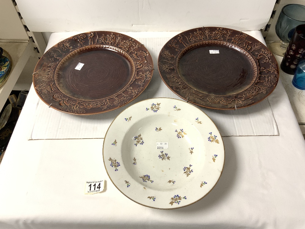 A PAIR OF BROWN GLAZED T G GREEN PLATES WITH EMBOSSED HUNTING SCENE BORDERS, 31 CMS, AND A DERBY