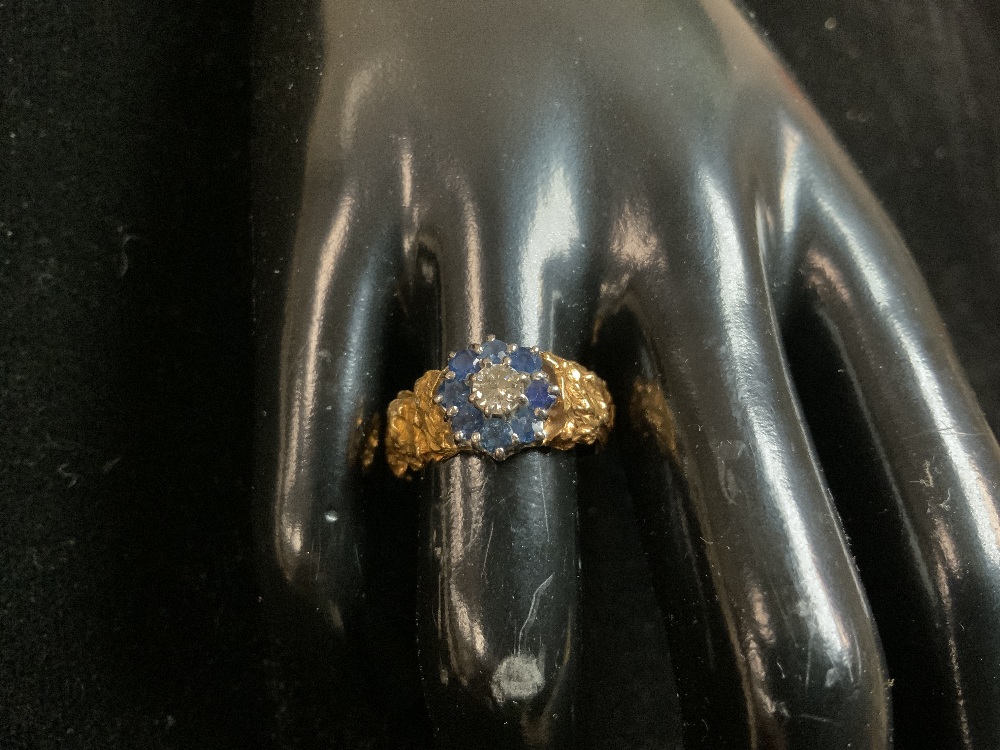 MARKS RUBBED GOLD RING WITH SINGLE DIAMOND SURROUNDED WITH SAPPHIRES SET IN PLATINUM; SIZEO; 7