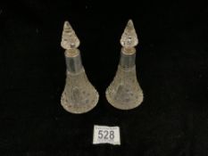 A PAIR OF EDWARDIAN HALLMARKED SILVER MOUNTED CUT GLASS CONICAL SHAPED SCENT BOTTLES AND STOPPERS;