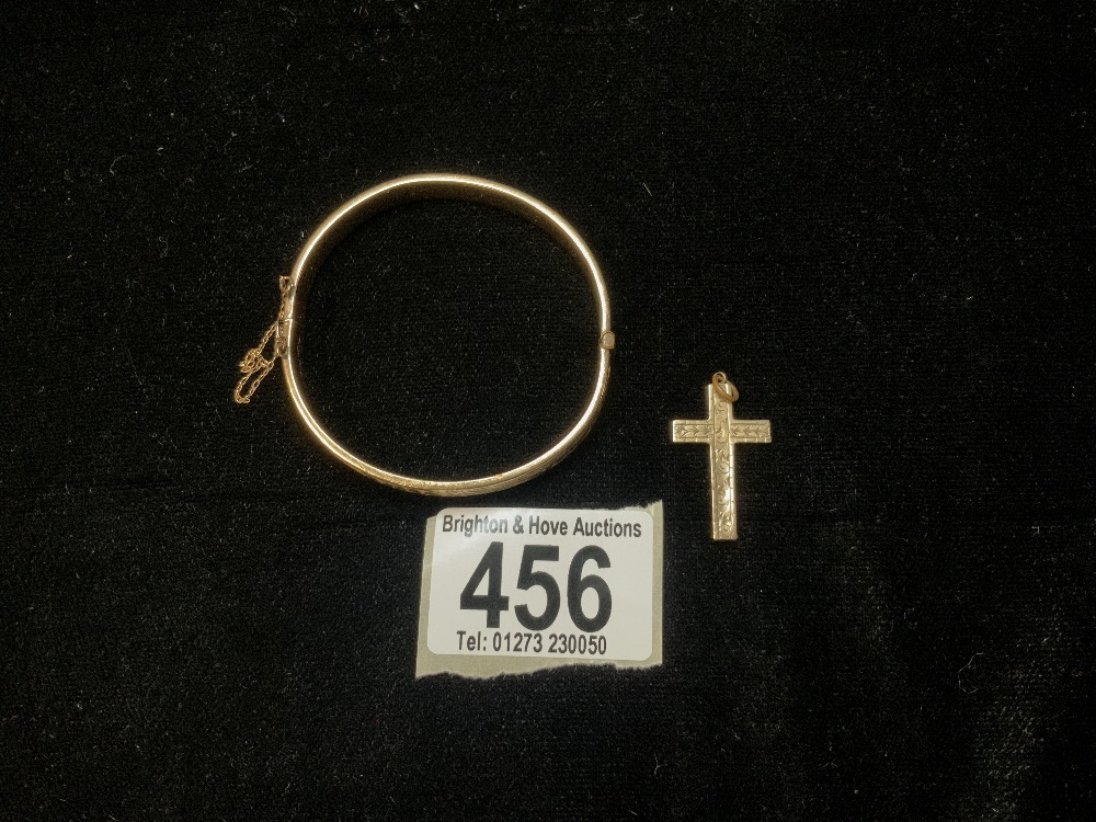 A 9CT GOLD AND METAL CORE BANGLE, AND A 9CT STAMPED CROSS PENDANT.