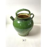 A GREEN GLAZED POTTERY WATER JUG; 28 CMS.