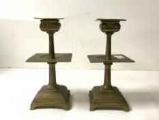 A PAIR OF ARTS AND CRAFTS SQUARE BRASS CANDLESTICKS, 17 CMS.