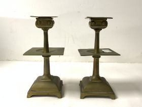 A PAIR OF ARTS AND CRAFTS SQUARE BRASS CANDLESTICKS, 17 CMS.