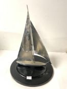 A 1950s CHROME SAILING BOAT MODEL ON CIRCULAR EBONISED BASE, 40 CMS.