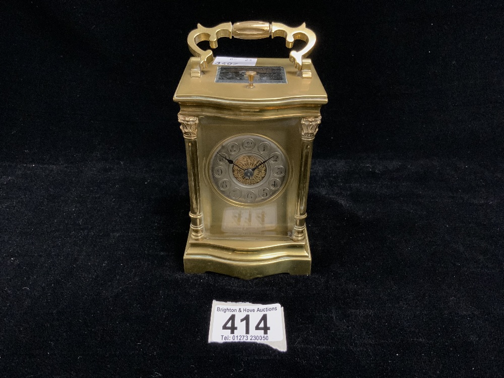 A FRENCH BRASS CARRIAGE CLOCK WITH FOUR PILLAR CAST SUPPORTS AND CIRCULAR SILVERED DIAL AND FILIGREE