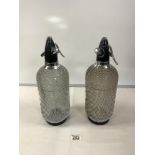 PAIR OF 1970'S GLASS AND METAL MESH SODA SYPHONS.