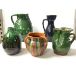 A GREEN GLAZED POTTERY JUG WITH APPLIED DECORATION; 24 CMS, A BLUE GLAZED POTTERY JUG, SLIP