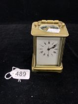 A BRASS CASED CARRIAGE CLOCK WITH WHITE ENAMEL DIAL; 12 CMS.