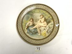 A CIRCULAR CERAMIC WALL PLATE DECORATED WITH SEMI - CLAD MAIDENS; 35 CMS.