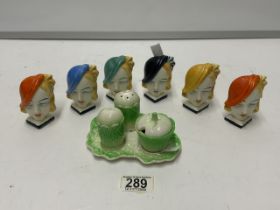 SET OF SIX PORCELAIN ART DECO LADIES NAPKIN HOLDERS AND A CRUET SET.