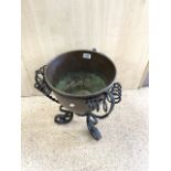 A COPPER JARDINERE WITH ORNATE WROUGHT IRON STAND; 32X45 CMS.