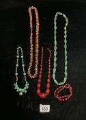 TWO CHERRY COLOURED BEAD NECKLACES, TWO GREEN HARDSTONE NECKLACES AND ANOTHER.