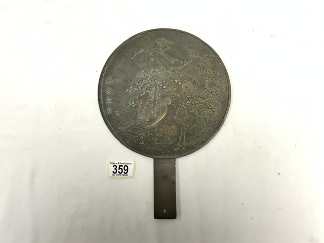 A CHINESE BRONZE HAND MIRROR WITH RELIEF DECORATION; 32 CMS.