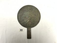 A CHINESE BRONZE HAND MIRROR WITH RELIEF DECORATION; 32 CMS.