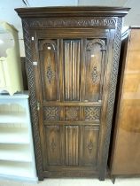 A CARVED LINEN FOLD OAK POLISHED WARDROBE; 90X46X200 CMS.