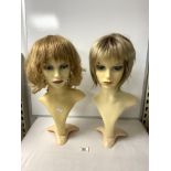 TWO MANNEQUIN BUSTS WEARING WIGS.