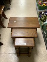 A NEST OF THREE SOLID OAK TABLES ON TURNED LEGS.