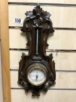 A SMALL CARVED BLACK FOREST BAROMETER.