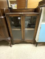 A 1930s GLAZED OAK TWO DOOR CABINET; 60X28X88 CMS.