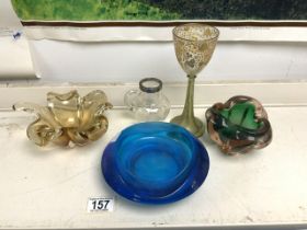 A GILDED GLASS WINE GOBLET, SMALL SILVER RIM GLASS JUG AND THREE ART GLASS DISHES.