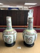 A PAIR OF 20TH-CENTURY CANTON PORCELAIN BOTTLE SHAPE VASES ON WOODEN STANDS, 35 CM.