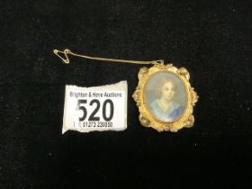 A GILT METAL OVAL BROOCH INSET WITH HANDPAINTED MINIATURE OF A YOUNG GIRL.