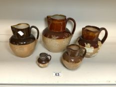 FIVE DOULTON STONEWARE HARVEST JUGS, 21.5 CMS LARGEST.