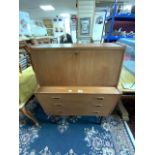 A MID-CENTURY TEAK THREE DRAWER BUREAU.