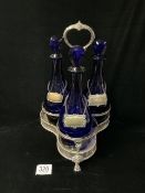 VICTORIAN SILVER-PLATED TRIFORM-SHAPED TANTALUS FITTED WITH THREE BRISTOL BLUE GLASS DECANTERS AND