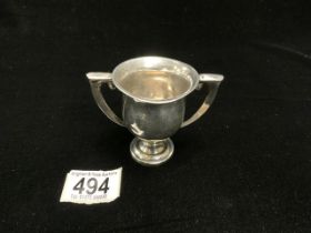 A SMALL TWO HANDLE TROPHY CUP MARKED STERLING; 54 GMS.