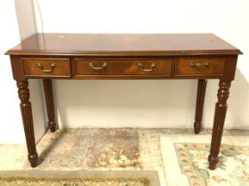 A REPRODUCTION INLAID MAHOGANY THREE DRAWER HALL TABLE ON REEDED LEGS, 122X50X76 CMS.