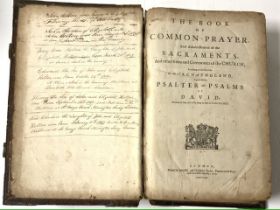 A 1679 LEATHER-BOUND BIBLE OF THE COMMON PRAYER WITH ORNATE BRASS CATCHES.