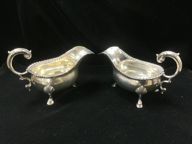 A PAIR OF GEORGE III HALLMARKED SILVER SAUCEBOATS WITH GADROONED RIMS AND SCROLL HANDLES ON HOOF - Image 3 of 4