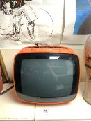 A RETRO INDESIT SPACE AGE ORANGE PLASTIC PORTABLE TELEVISION.