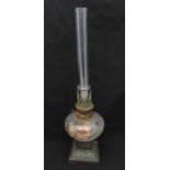 A 19th century oil lamp with painted glass oil well, clear glass funnel on raised square metal base,