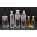 Six scent bottles with hallmarked silver covers