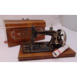 An antique sewing machine in mahogany case to include documentation