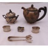 A quantity of white metal to include a teapot with wooden scroll handle, a fluted sugar bowl with